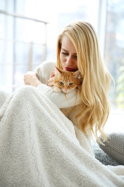 Genç kadın kırmızı kedi ile poz