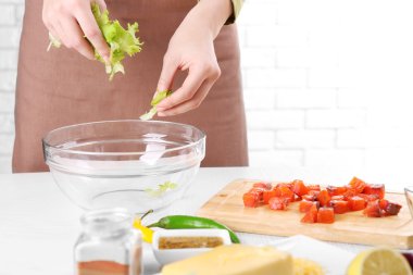 Marul yaprakları salata, bir kase içine ekleme eller yakın çekim