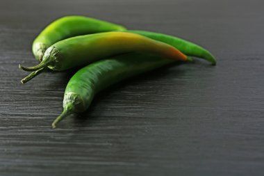 Koyu ahşap zemin üzerine yeşil biber