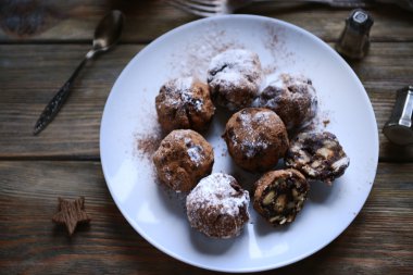Ahşap arka plan üzerinde bir tabakta çikolata topları