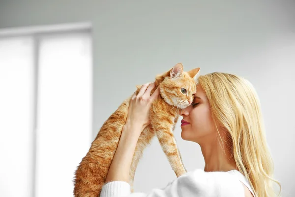 Frau hält rote Katze in den Händen — Stockfoto