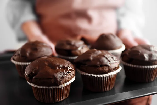 Casalinga che tiene il vassoio del forno con i cupcake al cioccolato, primo piano — Foto Stock