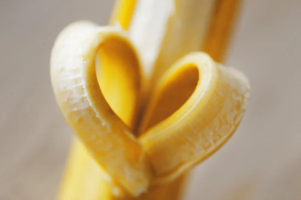 Coração feito de banana no fundo de madeira — Fotografia de Stock