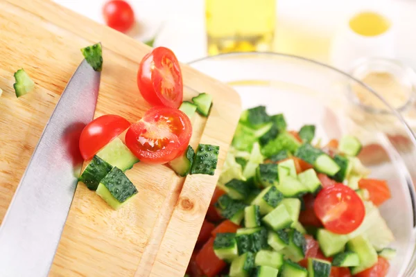 Frauenhände fügen Gemüse in Schüssel mit Salat hinzu, Nahaufnahme — Stockfoto