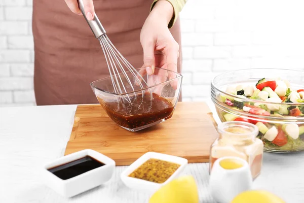 Mulher que prepara molho para salada, na cozinha — Fotografia de Stock