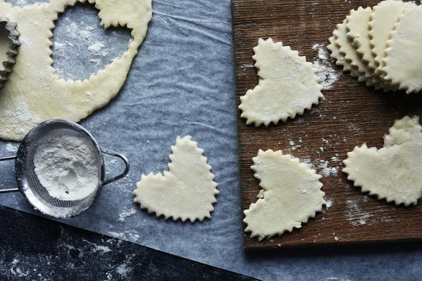 Uncooked heart shaped biscuits on a table — Stock Photo, Image