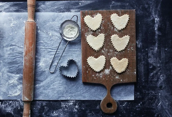 Biscotti a forma di cuore crudi su un tavolo — Foto Stock