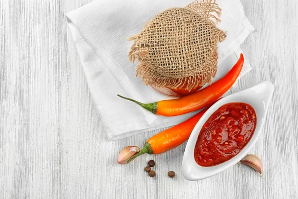 Homemade hot sauce and spices on light wooden background — Stock Photo, Image