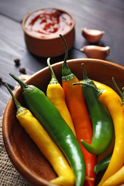 Peperoni, salsa piccante fatta in casa e spezie su sacco, su sfondo di legno — Foto Stock