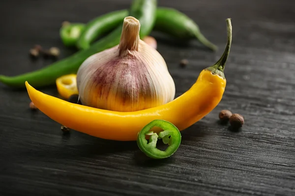 Ajo, ají verde y amarillo sobre fondo de madera oscura —  Fotos de Stock