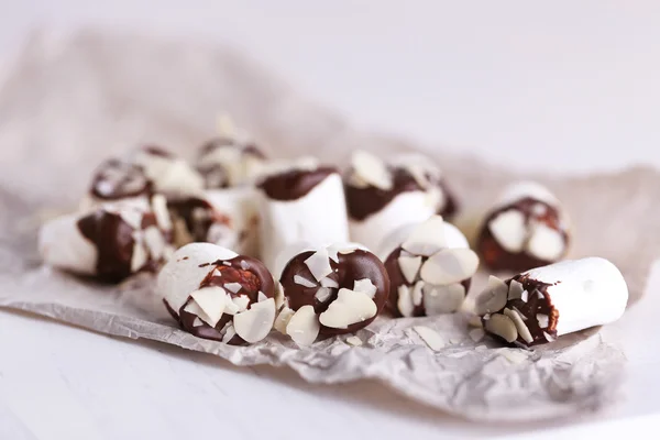 Tasty marshmallows with chocolate on paper, close up — Stock Photo, Image