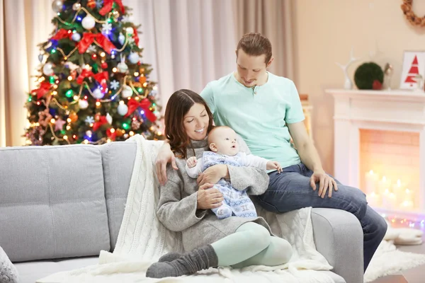 Familia feliz en el sofá en la habitación de Navidad —  Fotos de Stock