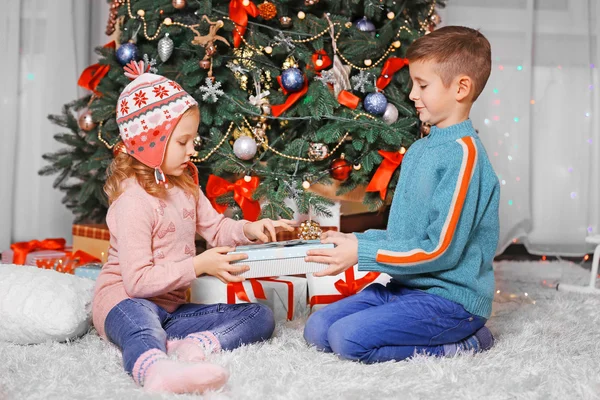 Happy children with gifts in Christmas room — Stock Photo, Image