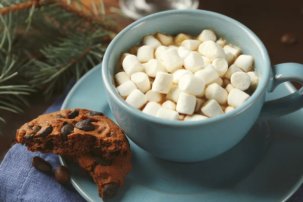 Hrnek horké čokolády s marshmallows, jedle větev stromu na dřevěné pozadí — Stock fotografie