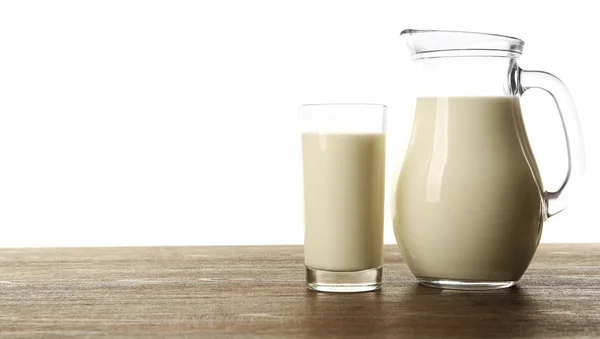 Mjölk i glas och i burken på bordet isolerad på vit bakgrund — Stockfoto