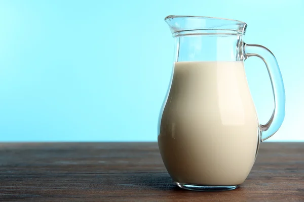 Jar of milk on table on blue background — Stock Photo, Image