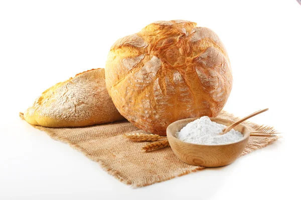 Pan con espigas y harina en servilleta aislada en blanco — Foto de Stock