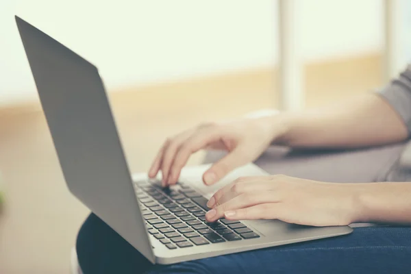 Frau sitzt mit Laptop auf Sofa — Stockfoto