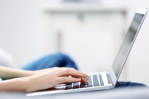 Frau sitzt mit Laptop auf Sofa — Stockfoto