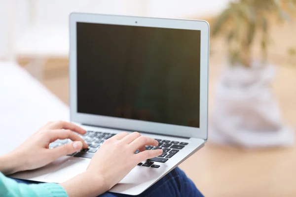 Vrouw zittend op de bank met laptop — Stockfoto
