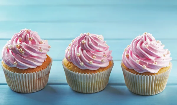 Cupcakes rosa no fundo de madeira — Fotografia de Stock