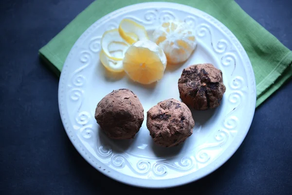 Chocolate balls with lemon on plate on dark blue background — Stock Photo, Image