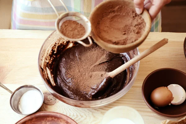 Woman preparing dough for chocolate pie on table close up — Stock Photo, Image