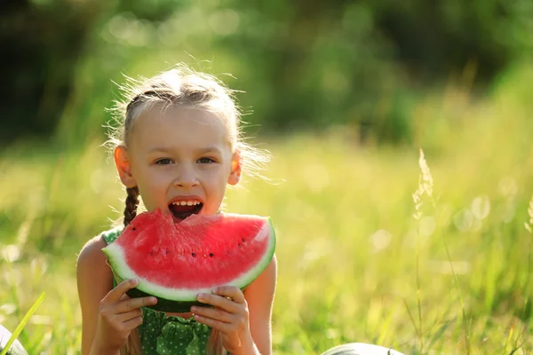 在草坪上吃西瓜的小女孩 — 图库照片