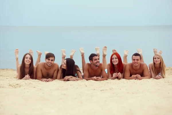 Jóvenes acostados en la playa —  Fotos de Stock