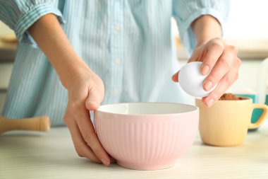 Woman is going to break an egg into a bowl