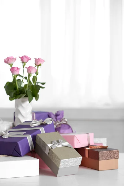 Композиція милих подарункових коробок і троянд на білому столі — стокове фото