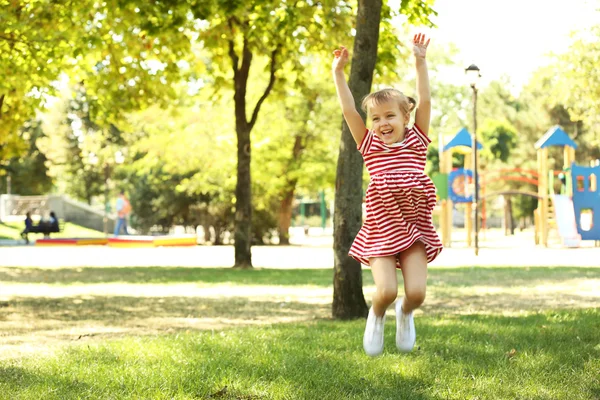 Little happy girl playing in park — Stock Photo, Image