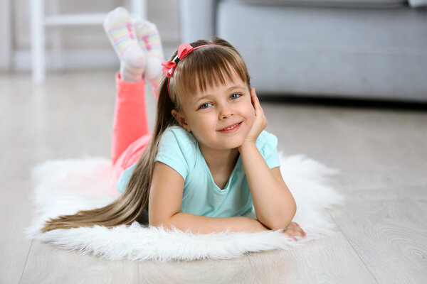 Little cute girl lying on carpet