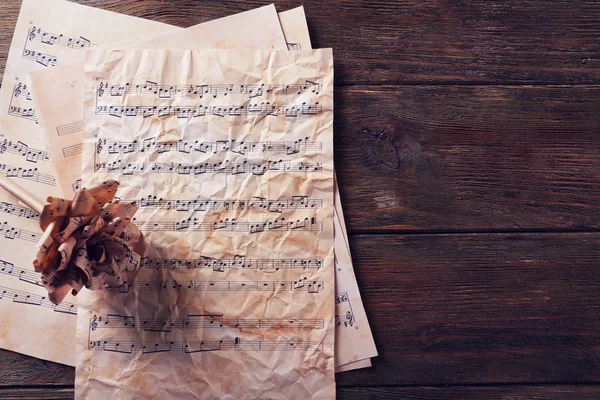 Paper-made rose on musical notes — Stock Photo, Image