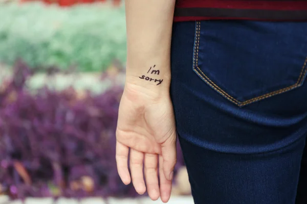 Hand van jonge vrouw met getatoeëerd zin — Stockfoto