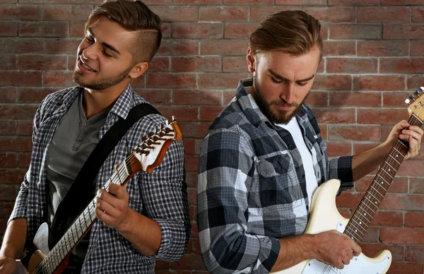 Hombres jóvenes tocando guitarras — Foto de Stock