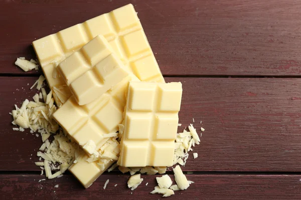 Witte chocolade stukjes op een houten achtergrond kleur — Stockfoto