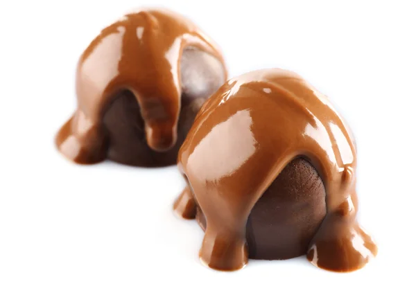 Cioccolato versato su caramelle isolate su bianco — Foto Stock