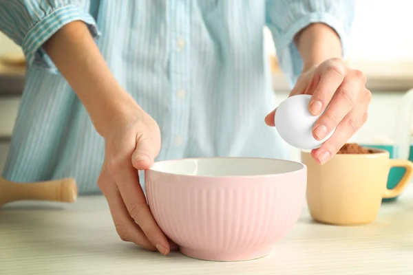 Woman is going to break an egg into a bowl — Stock Photo, Image