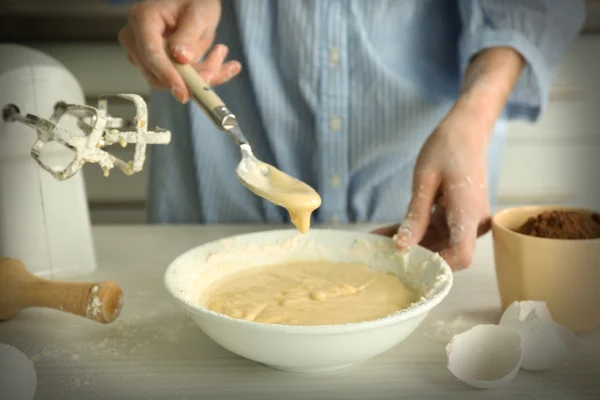 Woman is mixing dough with a spoon — Stock Photo, Image