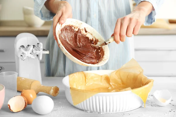 Woman is pouring dough into a baking tray — Stock Photo, Image