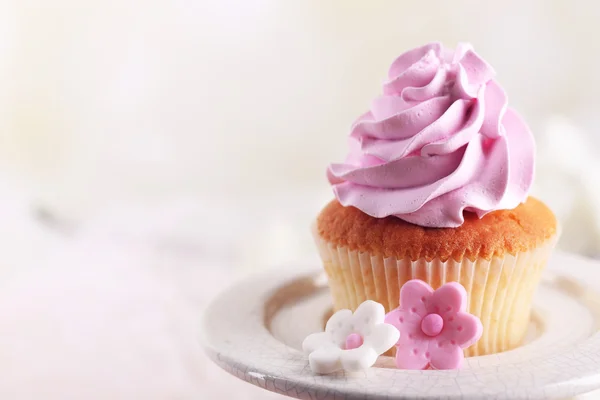 Leckere Cupcake am Stand, auf hellem Hintergrund — Stockfoto