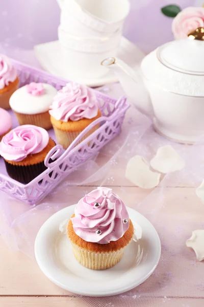 Välsmakande cupcake på tefat, på ljus bakgrund — Stockfoto