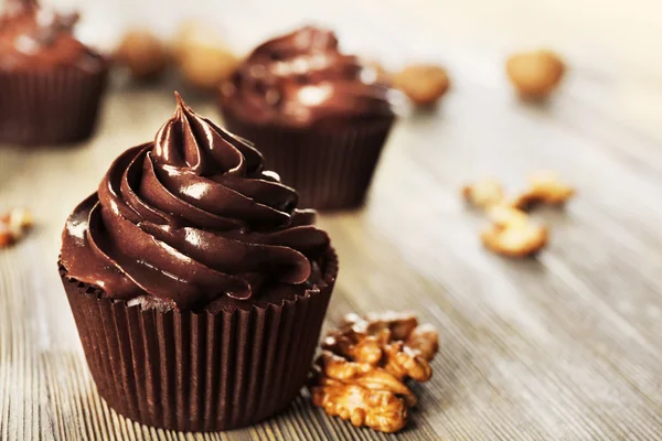 Schokoladen-Cupcakes mit Nüssen auf Holztisch — Stockfoto