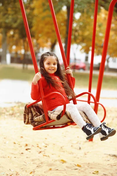 Meisje op schommel in stadspark — Stockfoto