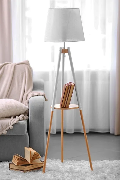 Sofá confortável com lâmpada e livro — Fotografia de Stock