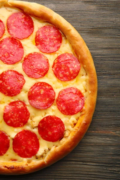 Sabrosa pizza con salami sobre fondo de madera, de cerca —  Fotos de Stock