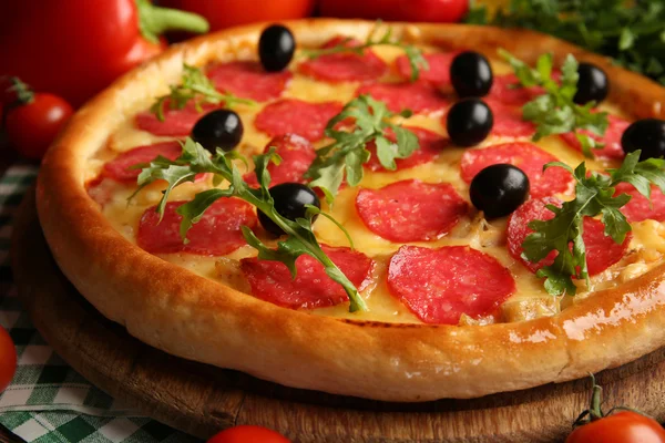 Gustosa pizza con salame sul tavolo di legno decorato, da vicino — Foto Stock