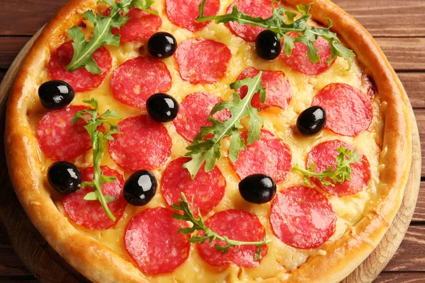 Gustosa pizza con salumi e olive su fondo legno — Foto Stock