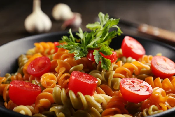 Prato de macarrão delicioso em tigela preta na mesa de madeira servida — Fotografia de Stock